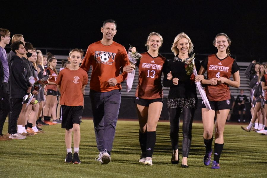 Senior Chloe Shaw walking down the field with her family and sister, sophmore Stella Shaw.