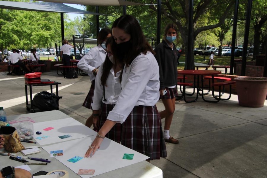 Seniors Sarah Ward and Mary Jackson Kirk pick up trading cards made by members of the art club.