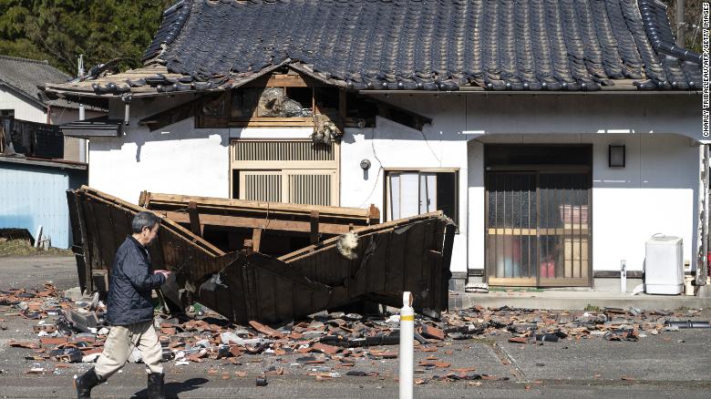 Sushi maker Akio Hanzawa walks in front of his damaged restaurant in Shiroishi, Miyagi prefecture on March 17, 2022, after a 7.3-magnitude earthquake jolted east Japan the night before. (Photo courtesy of CNN/Getty Images/CHARLY_TRIBALLEAU).
