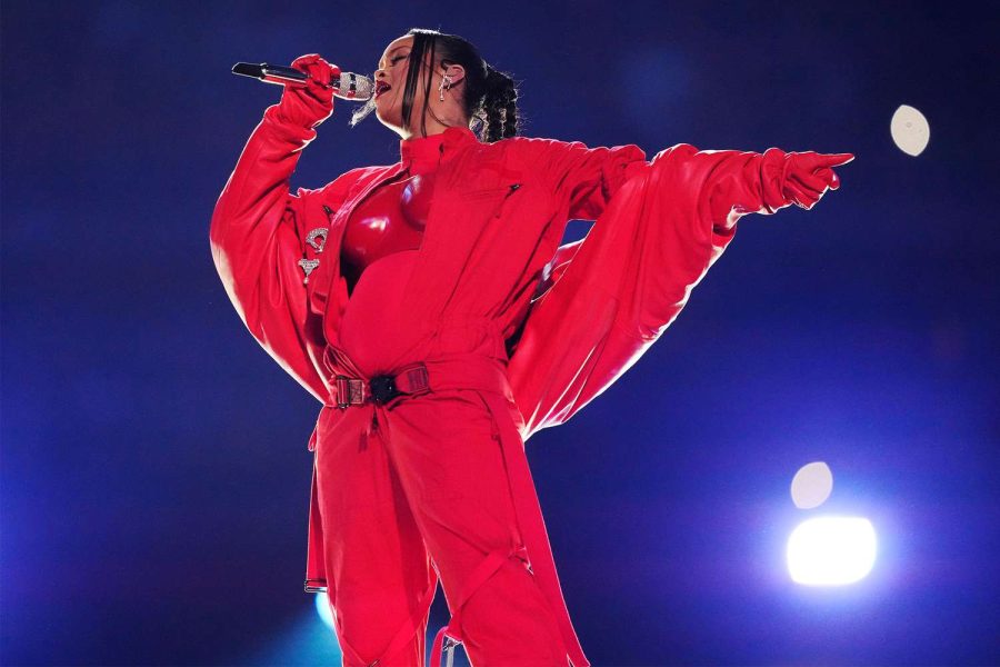 Rihanna shows off red outfit on stage. (Photo courtesy of People)