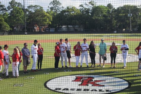 Boys lined up with their parents on senior night. 