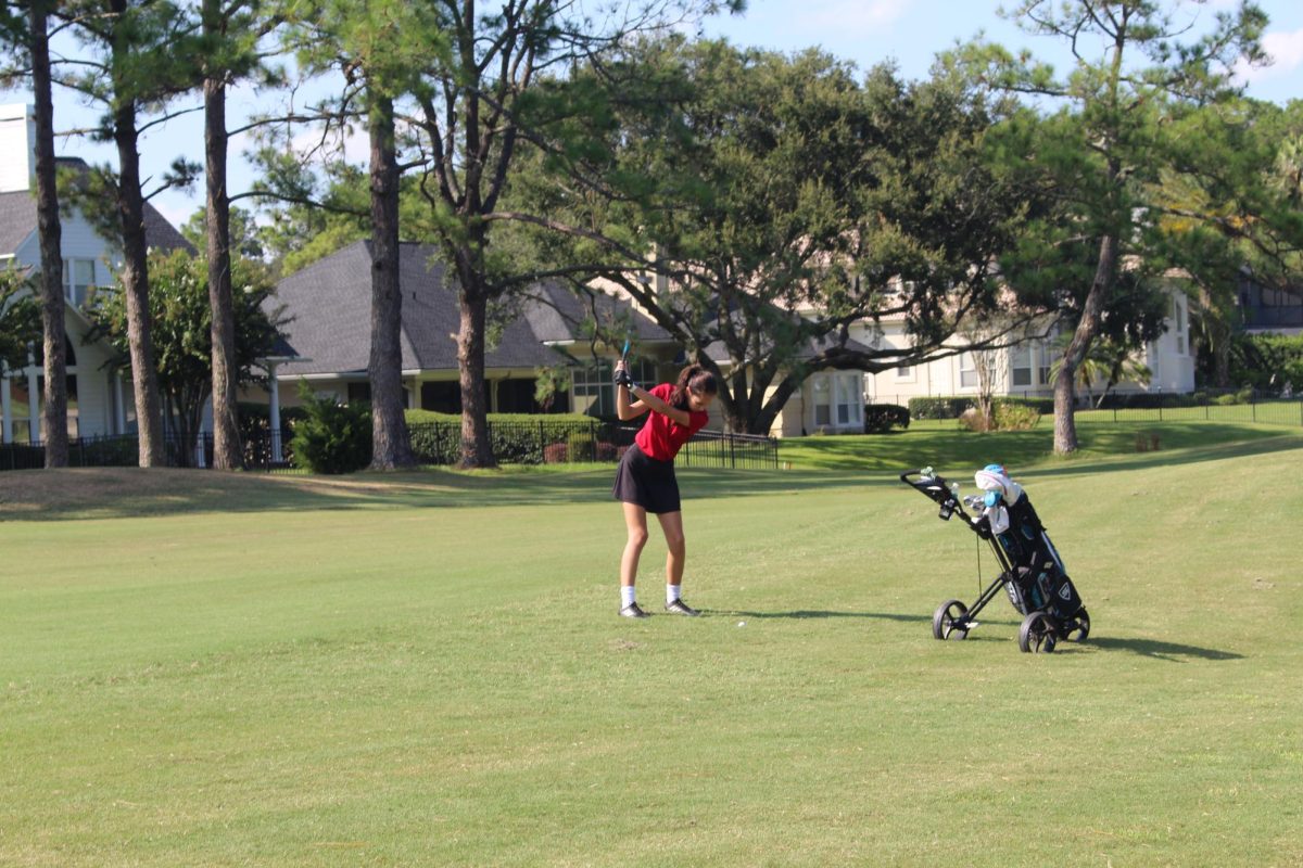 On the first hole, junior Andrea Kurth takes a swing at her second shot.
