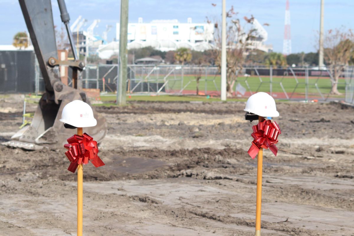 Shovels tied with bows, are used to celebrate the breaking of ground for the new athletic building.