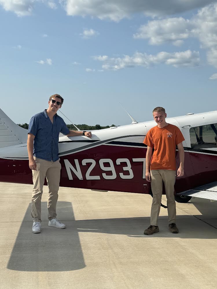 Lisowski stands next to the plane he flew with his flight instructor.